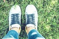 Young woman legs in sport shoes sneakers of blue suede, standing on the grass lawn in park Royalty Free Stock Photo