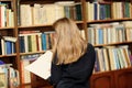 A young woman in the library reading a book