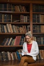 Young woman in library reading book Royalty Free Stock Photo