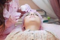 A young woman lies and gets a make-up of her eyebrows in a beauty salon. The use of permanent makeup on the eyebrows. The master w Royalty Free Stock Photo