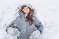 Young woman lies in a snowdrift and laughs Royalty Free Stock Photo