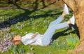 young woman lies under a tree in the park and enjoys spring sun and warmth Royalty Free Stock Photo