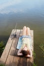 Young woman lies on wooden platform for fishing at Royalty Free Stock Photo