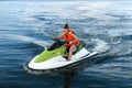 Young woman in a life jacket rides a water bike on a lake in summer Royalty Free Stock Photo