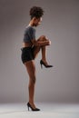 Balletic pose, woman in shimmering heels concentrates
