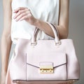 Young woman with light pink handbag, romantic casual style Royalty Free Stock Photo