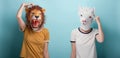 Young woman in lion and alpaca mask thinking, scratching her head, on blue