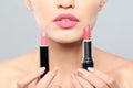 Young woman with lipsticks on gray background