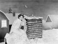 Young woman listening at chimney on snowy roof Royalty Free Stock Photo