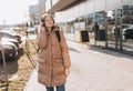 Young woman listening music in headphones in the city. Happy woman with backpack walking on the street. Urban lifestyle Royalty Free Stock Photo