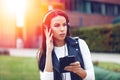 Young woman listening music on tablet by headphones looking away Royalty Free Stock Photo