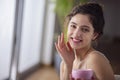 Portrait of a young woman applying moisturizer cream on her face Royalty Free Stock Photo