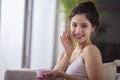 Portrait of a young woman applying moisturizer cream on her face Royalty Free Stock Photo