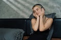 Young woman listening to music on headphone on her bed. Blithe