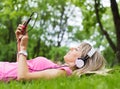 Young woman listening to music while laying down on grass Royalty Free Stock Photo