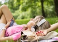 Young woman listening to music while laying down on grass Royalty Free Stock Photo