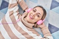 Young woman listening to music lying on floor at home Royalty Free Stock Photo