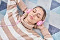 Young woman listening to music lying on floor at home Royalty Free Stock Photo