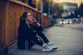 Young woman listening to music and resting after running on the bridge, at night Royalty Free Stock Photo