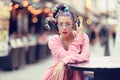 Young woman listening to music via headphones on the street - Hipster Girl with a nonconformist fashion look