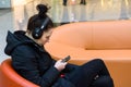 Young woman listens to music and reads message at smartphone. Royalty Free Stock Photo