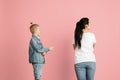 Young woman and little boy, mother and son isolated over pink background.