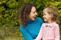 Young woman and little girl laugh in garden