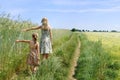 Young woman with a little girl walking on green field Royalty Free Stock Photo