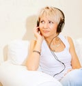 Woman in living room listening to MP3 player smiling Royalty Free Stock Photo