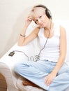 Woman in living room listening to MP3 player smiling Royalty Free Stock Photo