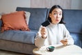 Young woman in living room, showing her credit card and using smartphone to pay, order online or shopping on application Royalty Free Stock Photo