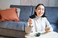 Young woman in living room, showing her credit card and using smartphone to pay, order online or shopping on application Royalty Free Stock Photo