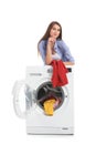 Young woman loading washing machine with dirty laundry Royalty Free Stock Photo