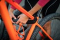 Young woman locking her mountain bike with a numeric lock, setting the code before leaving the bike on a city street