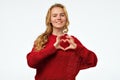 Pretty young woman with long blonde hair making a heart with her hands Royalty Free Stock Photo