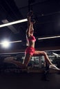 Young woman performing gymnastic exercise on rings Royalty Free Stock Photo