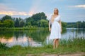 Young woman standing on the river bank during sunset Royalty Free Stock Photo