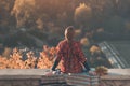 Young woman with long braid sits on a hill overlooking the village. Back view Royalty Free Stock Photo