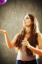 Young woman with long brown hair playing with purple ball. Royalty Free Stock Photo