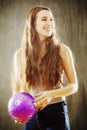 Young woman with long brown hair playing with purple ball. Royalty Free Stock Photo