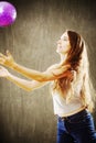 Young woman with long brown hair playing with purple ball. Royalty Free Stock Photo