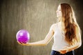 Young woman with long brown hair playing with purple ball. Royalty Free Stock Photo