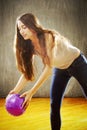 Young woman with long brown hair playing with purple ball. Royalty Free Stock Photo