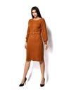 Young beautiful brunette woman with long hair in casual stylish crew neck long-sleeved dress with belt is walking