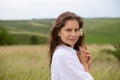 Horizontal photo of a young european woman who stands in a field with a flower in her hands Royalty Free Stock Photo