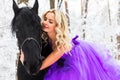 Young woman in long dress riding a horse in winter Royalty Free Stock Photo