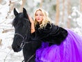 Young woman in long dress riding a horse in winter Royalty Free Stock Photo