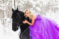 Young woman in long dress riding a horse in winter Royalty Free Stock Photo