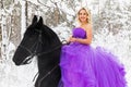 Young woman in long dress riding a horse in winter Royalty Free Stock Photo