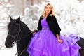 Young woman in long dress riding a horse in winter Royalty Free Stock Photo